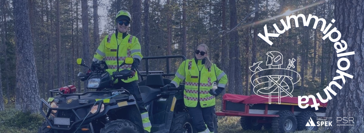 Kummipalokunta Yll&auml;ksen VPK kaksi aikuista kouluttajaa heijastinliiveiss&auml;. Toinen kyp&auml;r&auml; p&auml;&auml;ss&auml; m&ouml;nkij&auml;n sel&auml;ss&auml; ja toinen seisoo vieress&auml;.